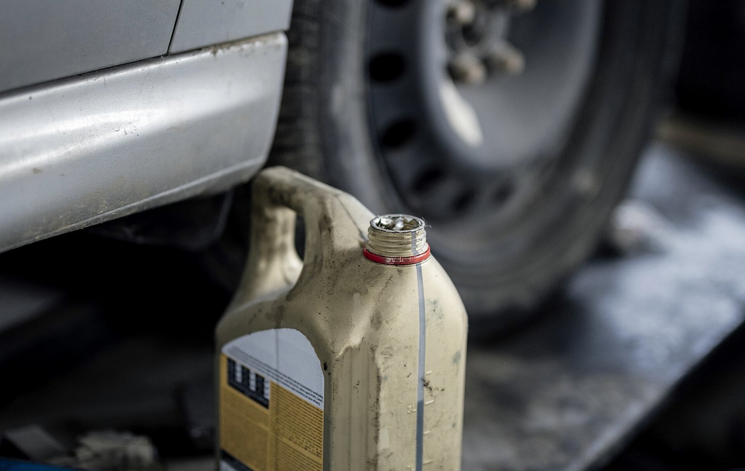 Car care bottles and a tire on a workshop lift shelf
