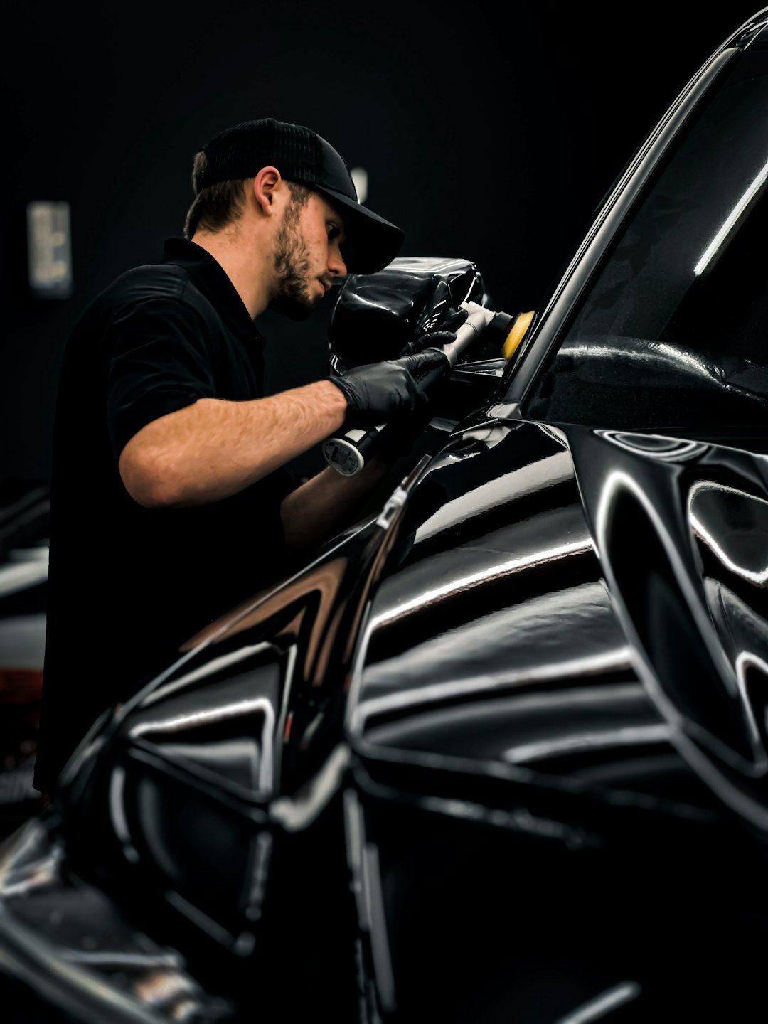 Polishing pad working on a dark painted car panel