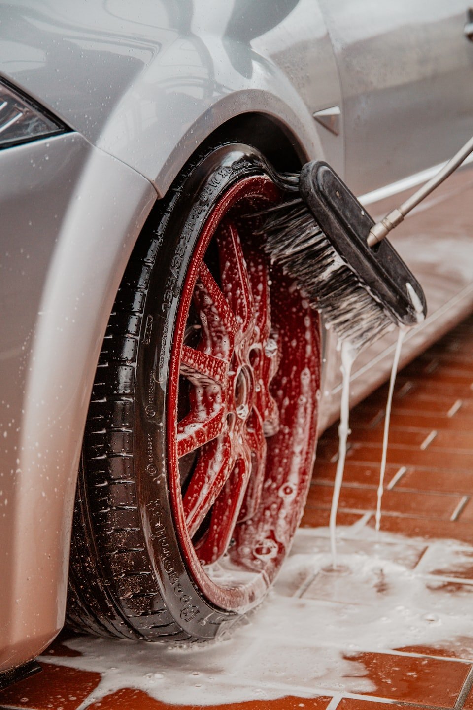 Foam and water around a red wheel during cleaning